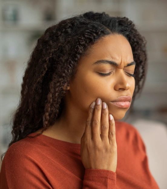 Woman experiencing tooth pain in need of emergency dental care at TRU Dentistry SoCo in South Austin, TX