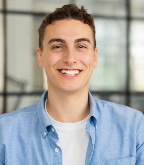 Young man smiling confidently after restorative dental treatment at TRU Dentistry SoCo in South Austin, TX