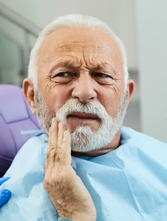 Senior man with tooth pain in need of tooth extraction at TRU Dentistry SoCo in South Austin, TX